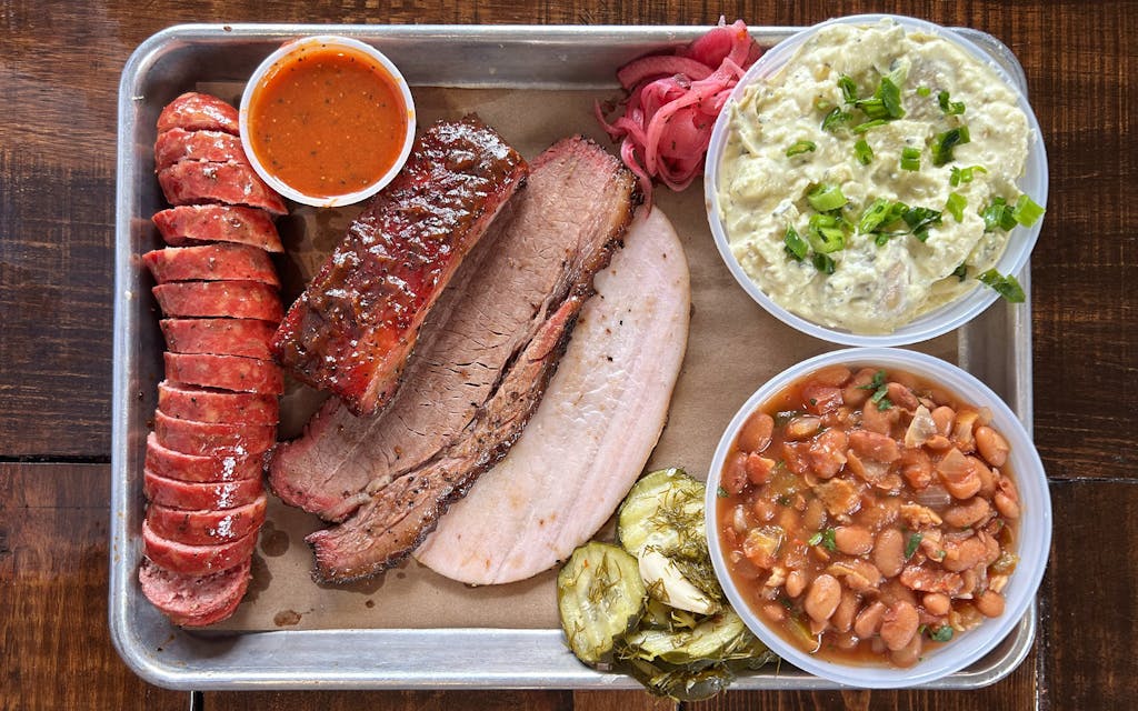 Burnt Bean Co. signature dishes Prime Brisket, Pork Spare Ribs, House-Made Sausages, Brisket Frito Pie, various specialty sides.